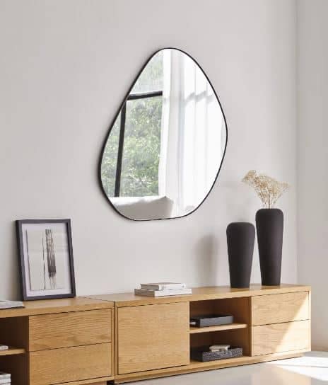 espejo de pared irregular con forma rara, con marco de perfil fino negro